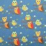 Orange & green owls on mid blue quilting fabric