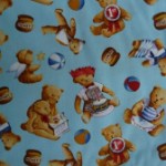 Teddies playing on blue quilting fabric 